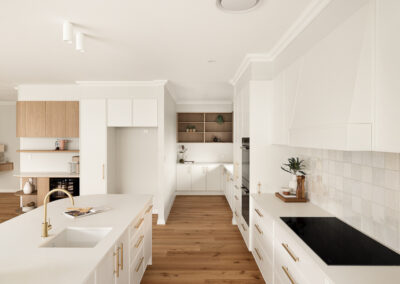 Modern white kitchen with a curved island, gold fixtures, built-in ovens, and an outdoor BBQ area