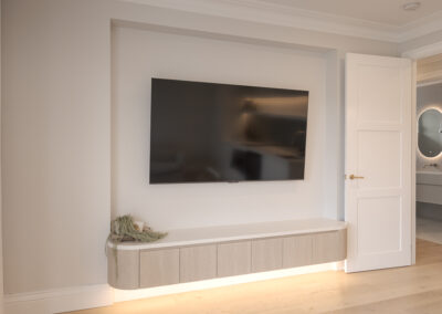 Custom white kitchen cabinetry with integrated storage and warm timber flooring in a modern Samford home