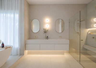 Custom white kitchen cabinetry with integrated storage and warm timber flooring in a modern Samford home