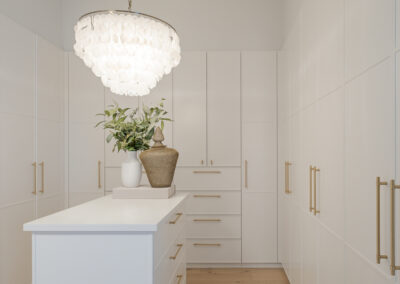 Custom white kitchen cabinetry with integrated storage and warm timber flooring in a modern Samford home