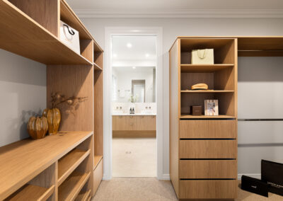 Walk-in robe cabinetry in Grange with warm timber shelving, drawers and custom joinery