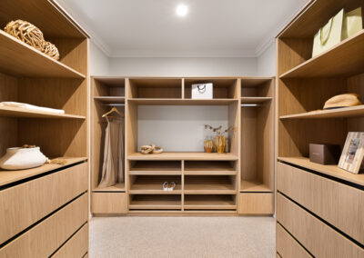 Custom walk-in robe in Grange with open shelving, hanging space and timber drawer cabinetry