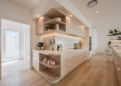 Custom coastal kitchen with curved open shelving, Soft Oak cabinetry and island bench
