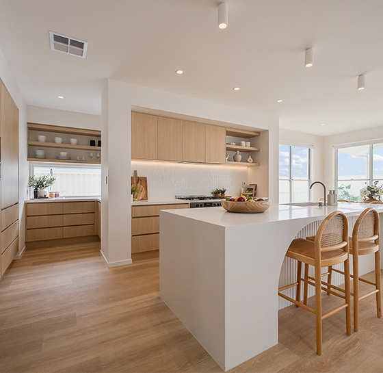 Custom home bar with mesh display cabinetry, stone benchtop, bar seating and under-bench fridge by Zente Kitchens