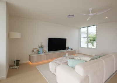Living room with custom TV cabinetry, fluted wall detail and floating entertainment unit