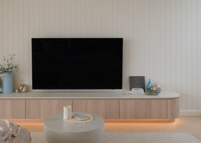 Custom floating TV unit with timber-look cabinetry, LED lighting and vertical wall panelling