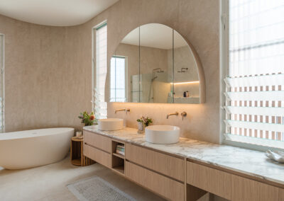 Bathroom vanity with arched mirror, double basins, stone benchtop and timber-look cabinetry