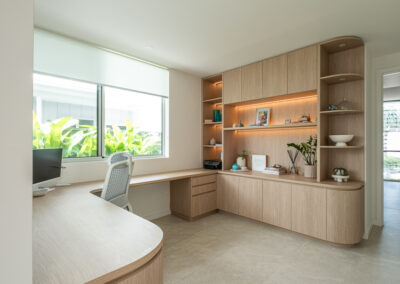 Custom home office cabinetry with timber-look desk, open shelves and feature lighting