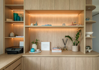 Built-in study cabinetry with open shelves, desk storage and warm integrated lighting