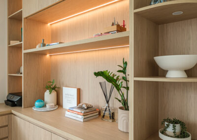 Custom office shelving with curved timber cabinetry, display shelves and warm LED lighting