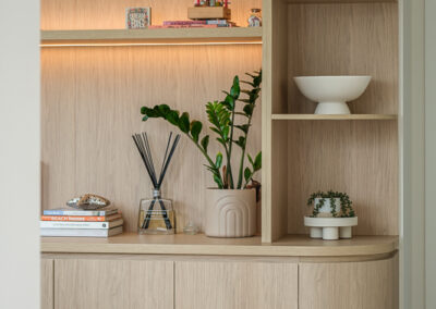 Home office shelving detail with timber-look cabinetry, open shelves and warm display lighting